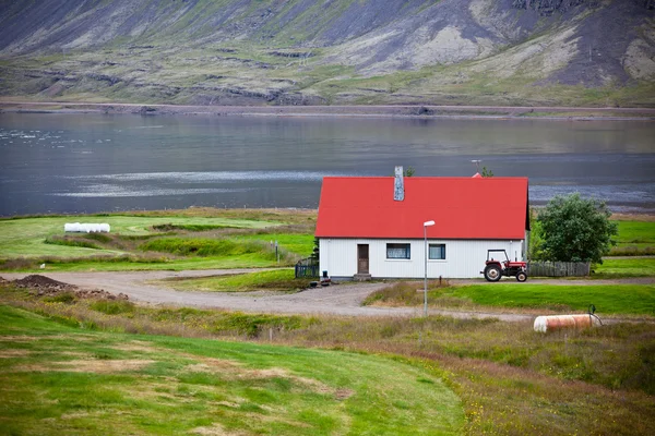 Typisk bondgård på isländska fjorden seglar utmed kusten — Stockfoto