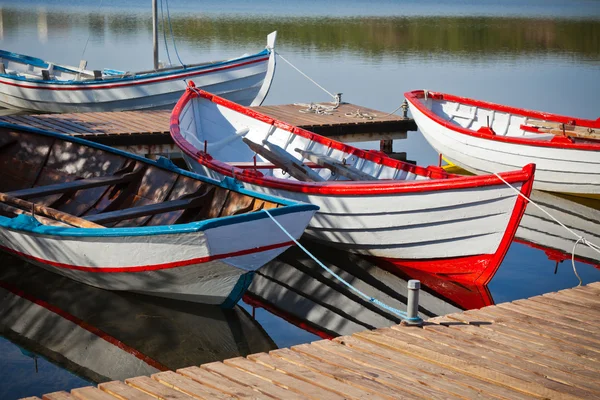 Flytande färg träbåtar med paddlar i en sjö — Stockfoto