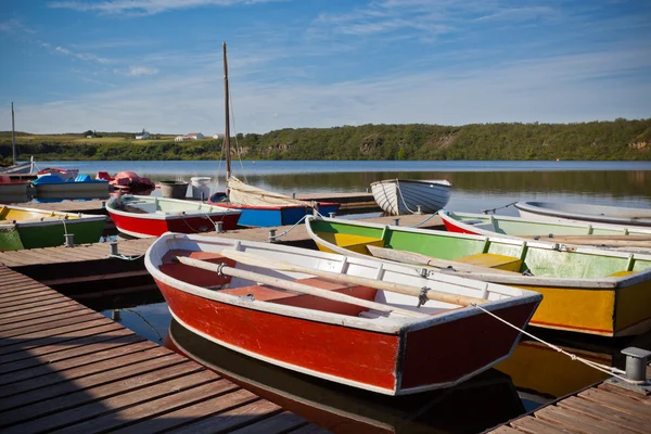 Flytande färg träbåtar med paddlar i en sjö — Stockfoto