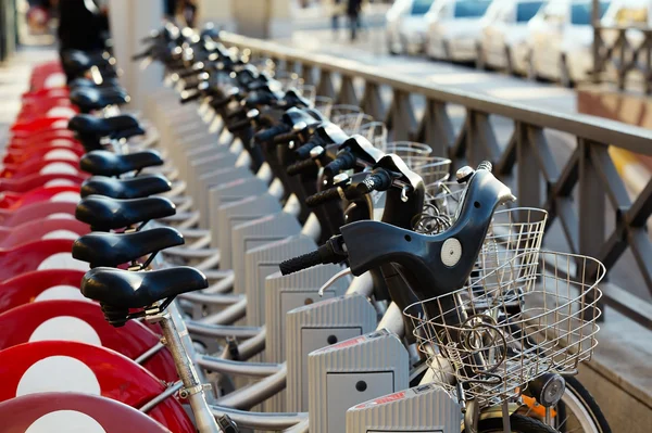 Alquiler de bicicletas en la ciudad estacionadas en fila —  Fotos de Stock