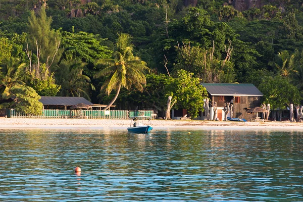 Старая рыбацкая лодка на тропическом пляже на Сейшельских островах — стоковое фото