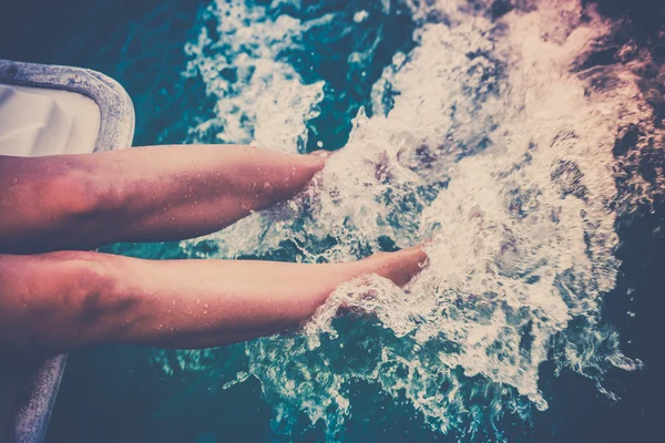 Frauenbeine spritzen Meerwasser von einer Segeljacht — Stockfoto