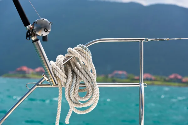 Une corde attachée autour d'une corde de sauvetage et une canne à pêche sur un yacht — Photo