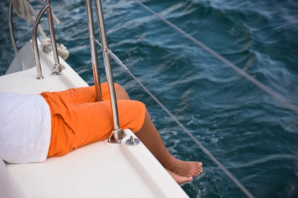 Mladý chlapec sedí na boku jachty — Stock fotografie