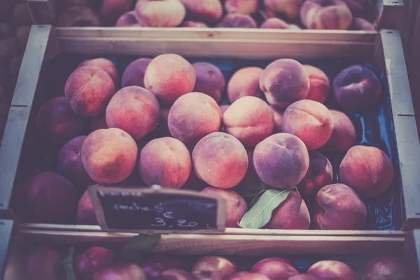 Duraznos frescos maduros en un mercado de agricultores — Foto de Stock