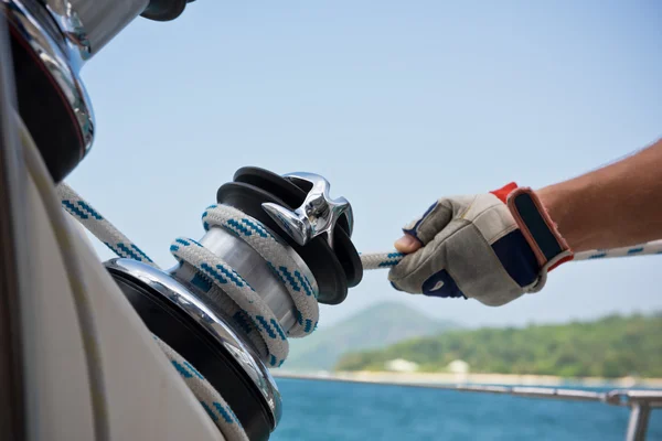 Winch and sailors hands on a sailboat — Stock Photo, Image