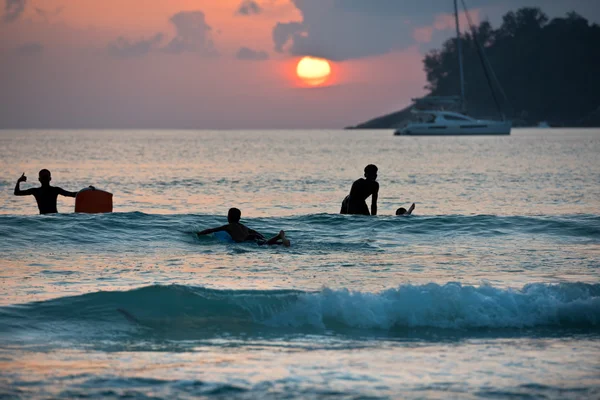 Boys on boards in sunset — Stock Photo, Image