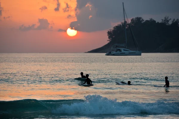 Boys on boards in sunset — Stock Photo, Image