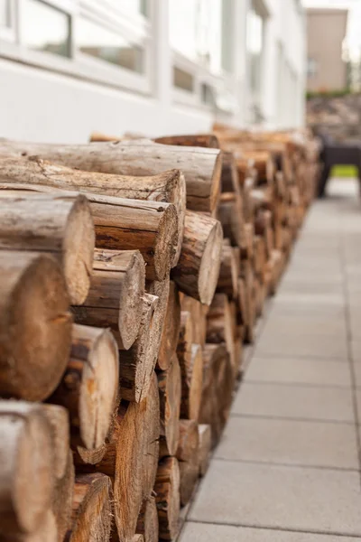 Logs pilha de madeira perto da parede — Fotografia de Stock