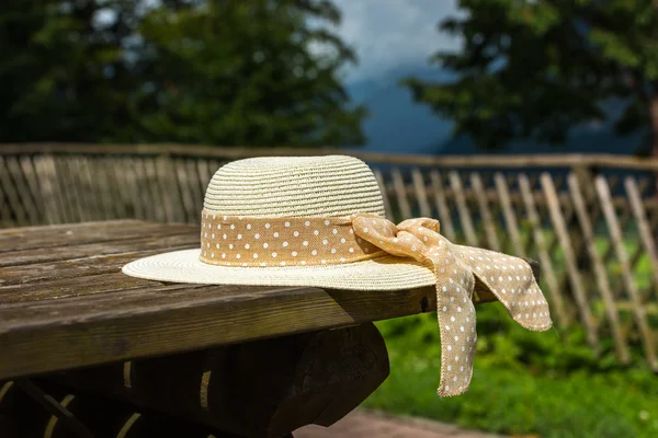 Cappello estivo femminile posato sul tavolo rustico in legno — Foto Stock