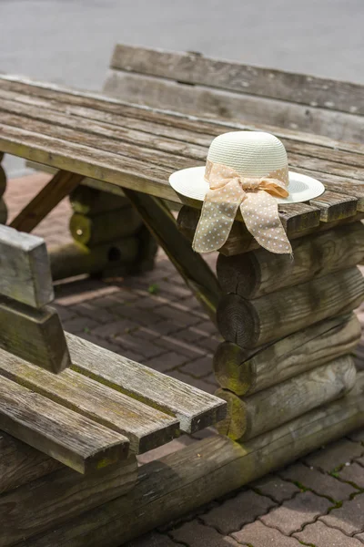Female summer hat laying on the wooden rustic table