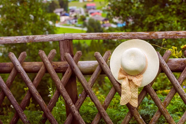 Жіночий літній капелюх, що звисає на дерев'яному сільському паркані — стокове фото