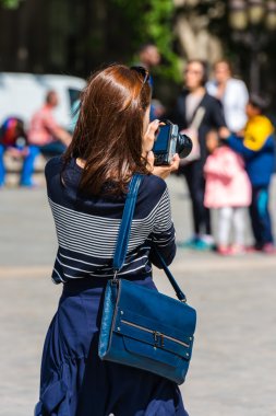 Genç bir kadın fotoğraf çekiyor.