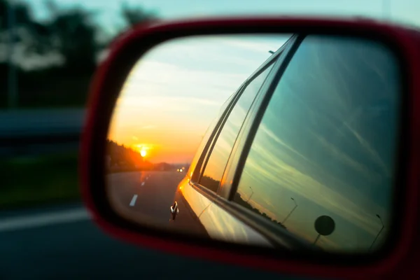 Zonsondergang weerspiegeling in de achteruitkijkspiegel — Stockfoto