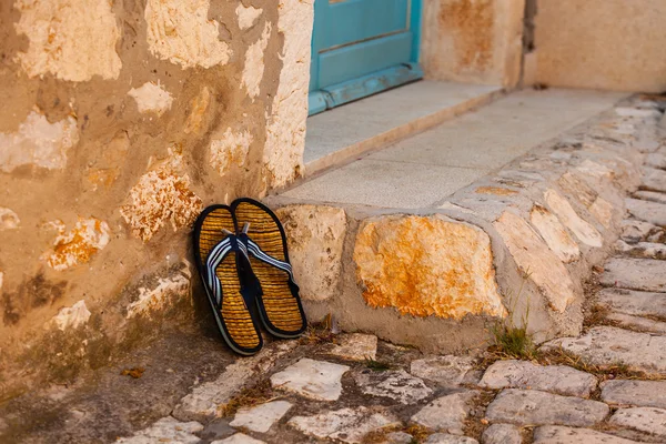 Beach flip-flops on the old wall — Stock Photo, Image