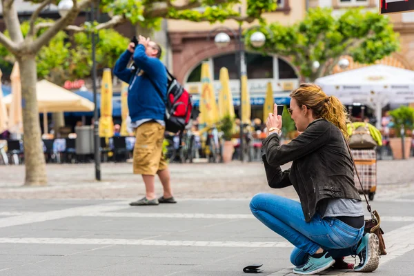 Ung kvinna tar en bild med sin telefon — Stockfoto