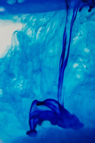 Líquido azul na água fazendo formas abstratas — Fotografia de Stock