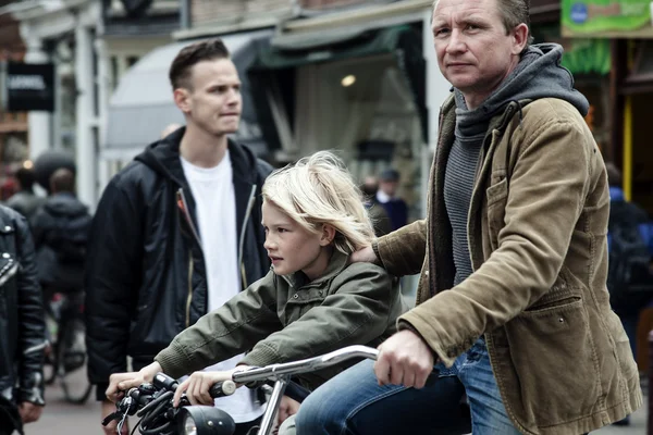 AMSTERDAM, NETHERLANDS - MAY 9:  Father with son riding bicycles in historical part in Amsterdam, Netherlands on May 9, 2015