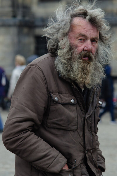 Amsterdam, The Netherlands - May 9, 2015: old poor  man walking by the streets of  Amsterdam on May 9, 2015 in Amsterdam, Holland