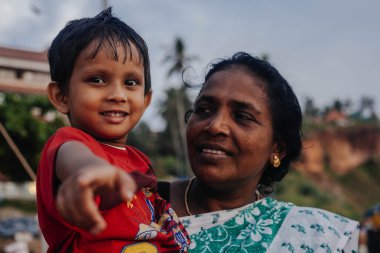 Varkala, Kerala, Hindistan - 15 Aralık 2012: portre Hintli anne puja törenle kutsal yere - Papanasam sahilde Varkala üzerinde çocuk ile 