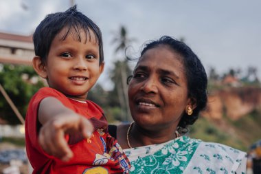 Varkala, Kerala, Hindistan - 15 Aralık 2012: portre Hintli anne puja törenle kutsal yere - Papanasam sahilde Varkala üzerinde çocuk ile 