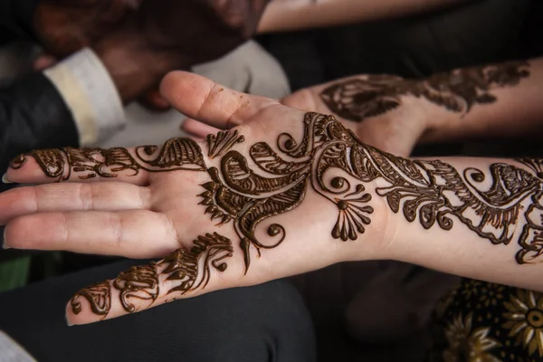 VARANASI , INDIA-  NOVEMBER 13, 2012: indian street  master uses  henna paste or mehndi application on white  tourist woman hand. Traditional Indian natural skin decoration, bio-tattoo — Stock Photo, Image