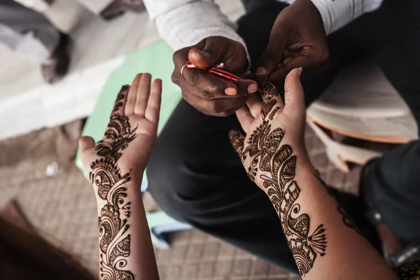 VARANASI, INDE - 13 NOVEMBRE 2012 : maître de rue indien utilise de la pâte de henné ou application mehndi sur main de femme touriste blanche. Décoration traditionnelle indienne en peau naturelle, bio-tatouage — Photo