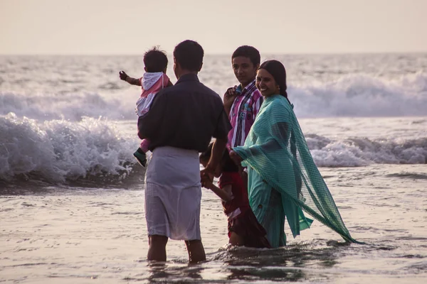 VARKALA, KERALA, INDIA - 15 DICEMBRE 2012: Una famiglia indù non identificata fa il bagno sacro alla confluenza sacra sulla spiaggia di Papanasam — Foto Stock
