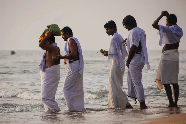 Varkala, India - 15 Dec 2012: Pelgrims lopen naar de zee te bieden puja. Dit is een heilige plaats. Pelgrims komen hier om een heilige duik nemen in het Heilige water van het strand. — Stockfoto