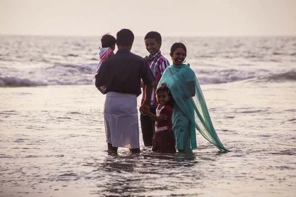 VARKALA, KERALA, INDIA - DECEMBER 15 , 2012: Unidentified Hindu family do holy bathe at the sacred confluence on  Papanasam beach — Stock Photo, Image