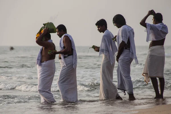 VARKALA, INDIA - DEC 15, 2012: I pellegrini scendono al mare per celebrare il puja. Questo e 'un luogo sacro. I pellegrini vengono qui per fare un tuffo nelle acque sante della spiaggia . — Foto Stock