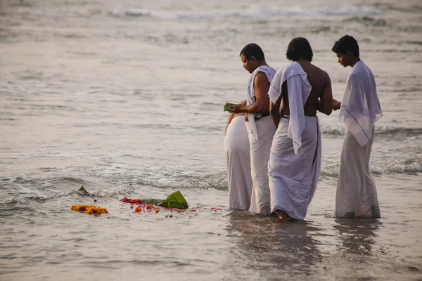 VARKALA, INDIA - DEC 15, 2012: I pellegrini scendono al mare per celebrare il puja. Questo e 'un luogo sacro. I pellegrini vengono qui per fare un tuffo nelle acque sante della spiaggia . — Foto Stock