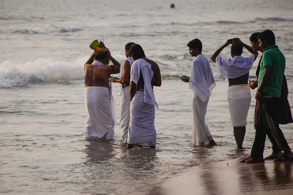 Varkala, India - 15 Dec 2012: Pelgrims lopen naar de zee te bieden puja. Dit is een heilige plaats. Pelgrims komen hier om een heilige duik nemen in het Heilige water van het strand. — Stockfoto