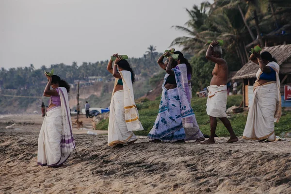 Varkala, India - 15 Dec 2012: Pelgrims lopen naar de zee te bieden puja. Dit is een heilige plaats. Pelgrims komen hier om een heilige duik nemen in het Heilige water van het strand. — Stockfoto