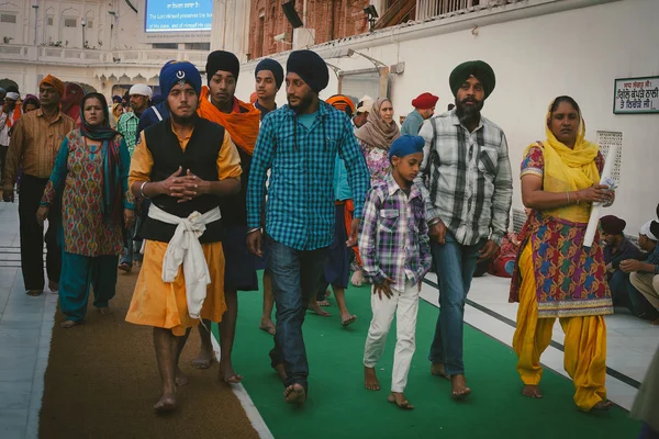 AMRITSAR, INDIA - 28 DE NOVIEMBRE DE 2013: Sijs no identificados y gente india visitando el Templo Dorado en Amritsar, Punjab, India el 28 de Noviembre de 2013. Los peregrinos sij viajan desde toda la India —  Fotos de Stock