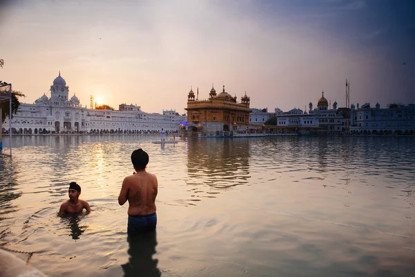 Amritsar, India, November - 28, 2013: Unidentified Sikh mannen bad in het heilige meer aan de gouden tempel (Harmandir Sahib ook Darbar Sahib) in de vroege ochtend. — Stockfoto