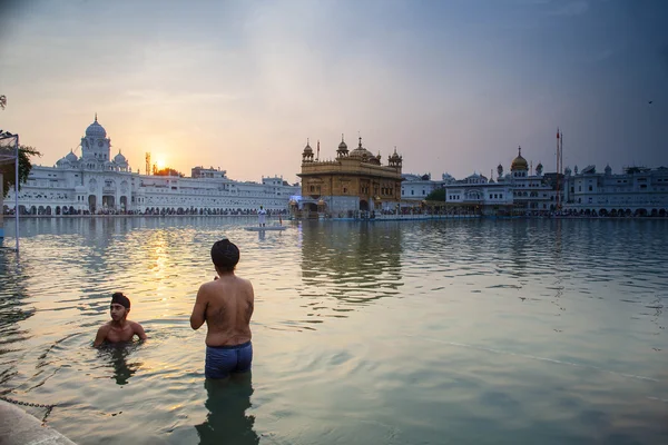 AMRITSAR, INDIA, NOVEMBER  - 28, 2013: Unidentified Sikh men bath in the holy lake at Golden Temple (Harmandir Sahib also Darbar Sahib) in the early morning. — Stock Photo, Image