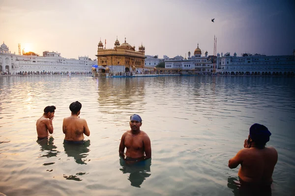 Amritsar, India, November - 28, 2013: Unidentified Sikh mannen bad in het heilige meer aan de gouden tempel (Harmandir Sahib ook Darbar Sahib) in de vroege ochtend. — Stockfoto