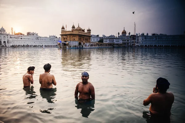 Amritsar, India, November - 28, 2013: Unidentified Sikh mannen bad in het heilige meer aan de gouden tempel (Harmandir Sahib ook Darbar Sahib) in de vroege ochtend. — Stockfoto