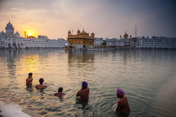 AMRITSAR, INDIA, NOVEMBRE - 28, 2013: Uomini Sikh non identificati si bagnano nel lago sacro al Tempio d'Oro (Harmandir Sahib anche Darbar Sahib) la mattina presto . — Foto Stock
