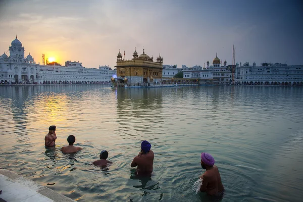 Amritsar, India, November - 28, 2013: Unidentified Sikh mannen bad in het heilige meer aan de gouden tempel (Harmandir Sahib ook Darbar Sahib) in de vroege ochtend. — Stockfoto