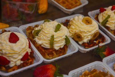 Geleneksel Belçika waffleları, köşedeki pastanede satılan tabaklar üzerinde yemeye hazır.