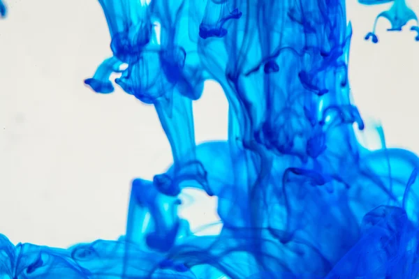 Líquido azul en agua haciendo formas abstractas — Foto de Stock