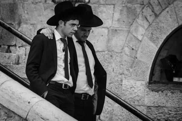 Un ebreo chassidico indossa un cappello di pelliccia e bekishe conduce i ragazzi lungo una passerella nella Città Vecchia di Gerusalemme. — Foto Stock