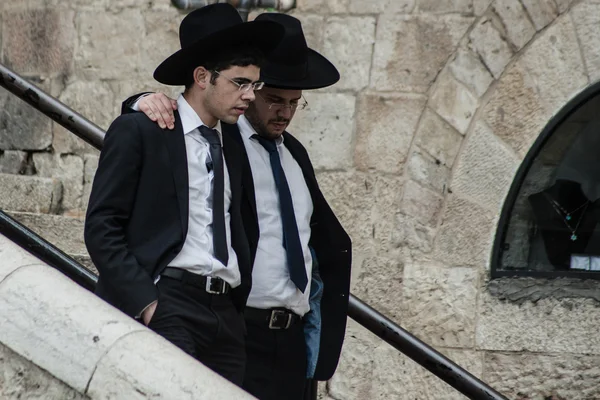 Un ebreo chassidico indossa un cappello di pelliccia e bekishe conduce i ragazzi lungo una passerella nella Città Vecchia di Gerusalemme. — Foto Stock