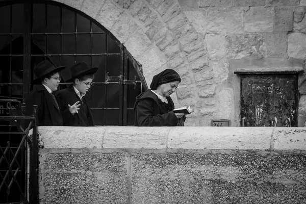 Egy zsidó ember egy szőr kalapot visel, és bekishe vezet fiatal fiúk, a sétány mentén, a régi város Jeruzsálem Hasidic — Stock Fotó