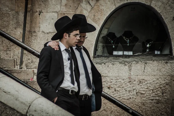 Un judío jasídico lleva un sombrero de piel y bekishe lleva a los jóvenes a lo largo de una pasarela en la Ciudad Vieja de Jerusalén —  Fotos de Stock
