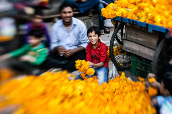 Man threading colourful flower garlands — Stock Photo, Image