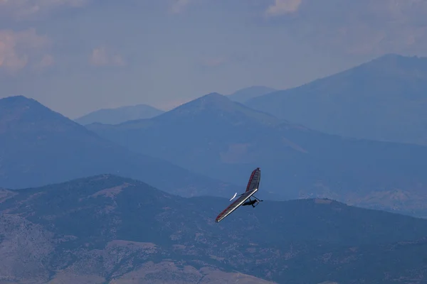 Planeador colgante volando en las montañas en Makedonia durante el europeo — Foto de Stock