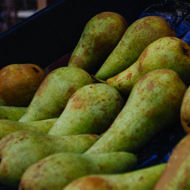 Piyasadaki pek çok büyük armut arasında taze organik sarı armut göze çarpıyor. Sarı armut meyvesi. Yakın çekim armut dokusu.